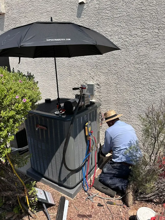 HVAC technician performing outdoor AC maintenance in Ashland