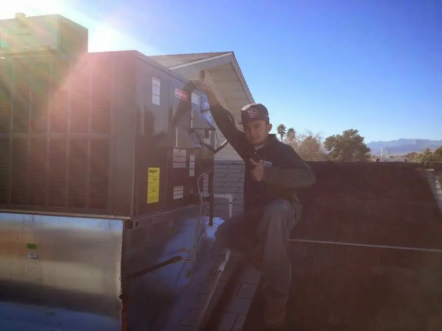 HVAC technician performing AC Tune-Up on a rooftop unit in Ashland